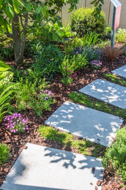 Dikey, güzel dikilmiş bir bahçede büyük taş levhalar ile yol