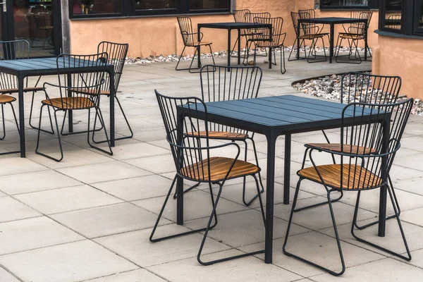 stock image Modern metal and wood table and chairs in a cafe