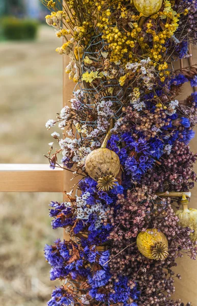 Beautiful decoration of dried flowers on a wooden beam, vertical