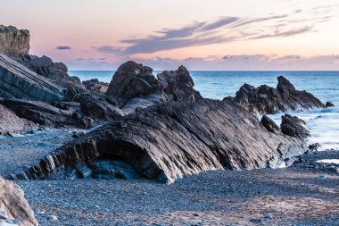 Cornwall 'ın kuzey sahillerinde kayalık oluşumlar akşam güneşinden sonra, güzel gökyüzü