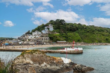 Looe, Cornwall, İngiltere - 13 Ağustos 2023: Yazın İngiltere 'nin Cornwall kentinde popüler bir tatil ve balıkçılık merkezi olan plajla East Looe' ya bakın.