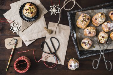 Advent 'te hediye sahnesi, mini stollen, kağıt torbalar, ve koyu ahşap arka planda hediye kurdelesi, noel konsepti