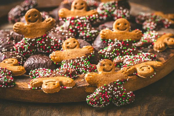 Tatlı noel kurabiyeleri, zencefilli ekmek, siyah ahşap bir masada.