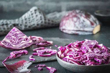 Taze kırmızı lahana, gri masada parçalara ayrılmış..