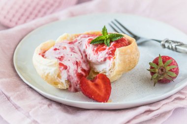 Krema ve çilek püresiyle doldurulmuş ev yapımı kruvasan ekmeği.