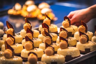 Bir fırın satıcısının eli satış tezgahına jöleli tart koyar. Sabahın erken saatlerinde satış için hazırlık..