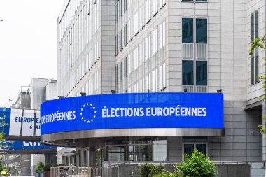 Brüksel, Belçika, 25.05.2024: Yaklaşan Avrupa Seçimlerini duyuran dev bir poster, Avrupa Parlamentosu binalarının cephelerine sıkıştı 