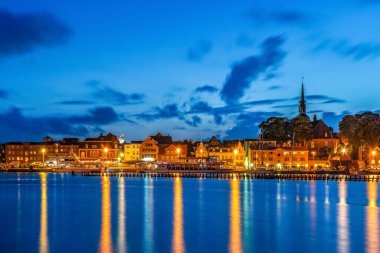 Mavi saatte Almanya 'nın küçük Kappeln kasabasının ufuk çizgisi manzarası. Şehir, Almanya 'nın en güzel tatil bölgelerinden biri olan Baltık Denizi Fjord Schlei' de yer almaktadır..