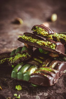 Dubai chocolate with pistachio cream, kadayif and pistachios on dark background clipart