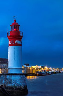 Fransa, Brittany 'de Le Guilvinec' in deniz feneri ve liman girişi mavi saatte, dikey.