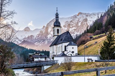Aziz Sebastian kilisesinin kışın alacakaranlık manzarası. Almanya 'nın Bavyera Alplerinde Ramsau' da yer almaktadır..