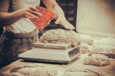 Baker hamuru bölüyor ve tartıyor. Buğdaylı vintage tarzı. 