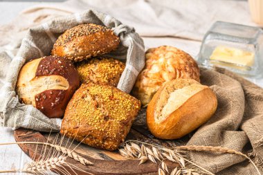 Lezzetli Alman çörekleri ve ekmek ruloları beyaz ahşap arka planda