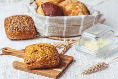 Lezzetli Alman çörekleri ve ekmek ruloları beyaz ahşap arka planda