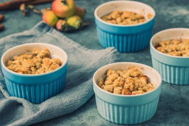 Elma kırsal gri bir masada küçük mavi kalıplarda ufalanır.