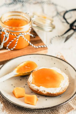 Ev yapımı mango reçelli çörek ve beyaz ahşap masada taze mango, dikey.