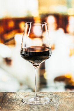 Tahta bir masada bir kadeh kırmızı şarap.