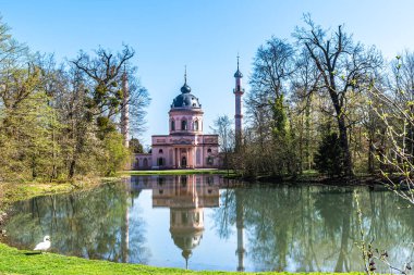 Almanya 'nın Schwetzingen kentindeki şato bahçesindeki pembe cami, güneşli bir bahar gününde mavi gökyüzü...