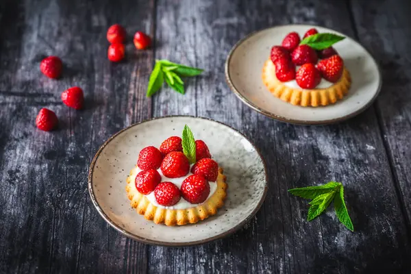 Ev yapımı çilekli turtalar kırsal siyah ahşap masada.