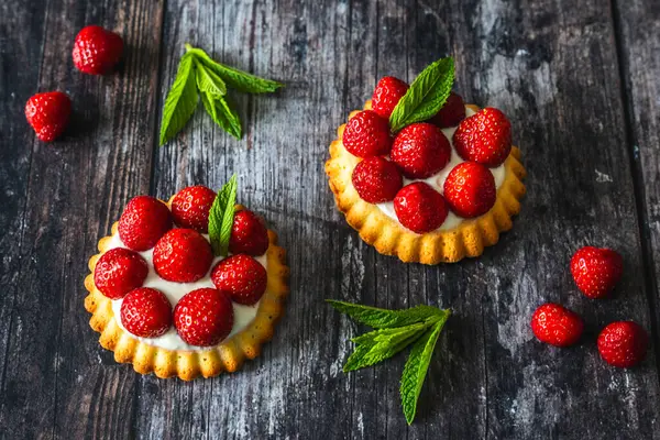 Ev yapımı çilekli turtalar kırsal siyah ahşap masada.