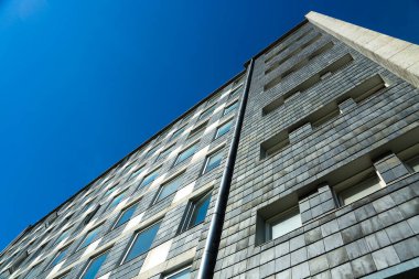 Düz çatılı modern ev, mavi gökyüzü.