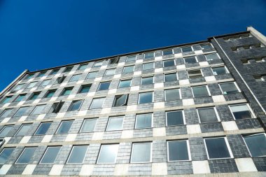 Düz çatılı modern ev, mavi gökyüzü.