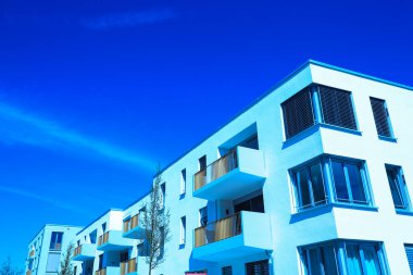 Yeni geliştirme alanı, düz çatılı modern evler, mavi gökyüzü.