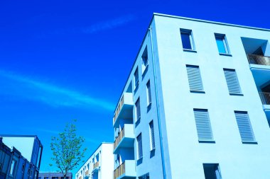 Yeni geliştirme alanı, düz çatılı modern evler, mavi gökyüzü.