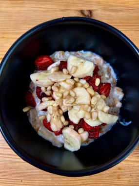 Beyaz tabakta ahududu ve çilekli yulaf lapası.