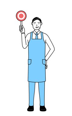 Elleri vücudunun önünde katlanmış önlüklü kıdemli bir adam..