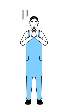 Önlüklü kıdemli bir adam elleri önünde özür diliyor..