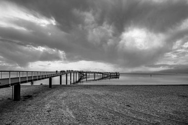 Die Maritim Seebruecke reicht rund zweihundertfnfzig Meter in die Ostsee und bietet dabei einen Rundweg von 427 Meter Laenge ueber dem Meer. In der Draufsicht kann ihre Form mit der einer ausgeworfenen Schlinge beschrieben werden.  ueberspannt  clipart