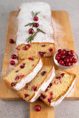 Blurred image of slices and cupcake with cranberries on a wooden board. The concept of baking.
