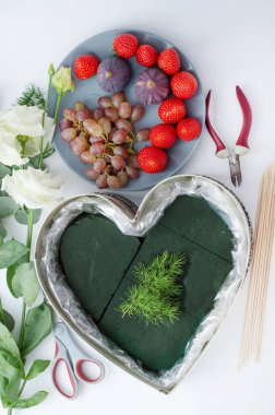 Flowers, berries, materials for creating a composition by a florist on a light table. Florist work concept.