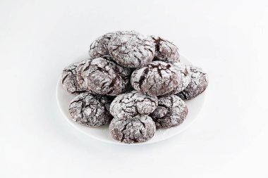 On a white background in a plate of cracked chocolate chip cookies. The concept of home baking.