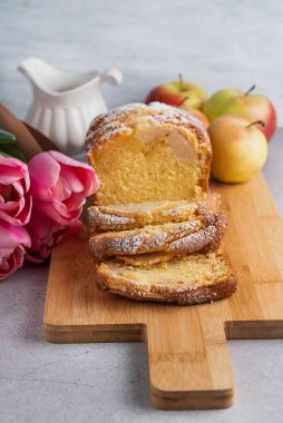 Tahta üzerinde elmalar, elmalar ve bir buket çiçek olan bulanık bir kek resmi..