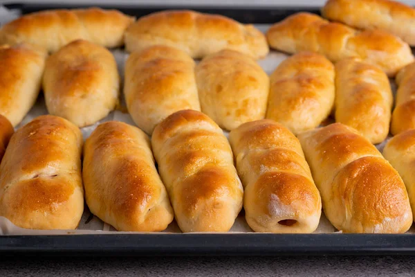 stock image Baked yeast buns on a baking sheet. The concept of home baking.