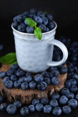 Koyu arkaplanda seramik bir fincanda yabanmersini. Yaz arkaplanı.