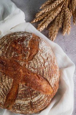 Gri arka planda çiftlik ekmeği ve buğday kulakları. Sağlıklı beslenme kavramı.