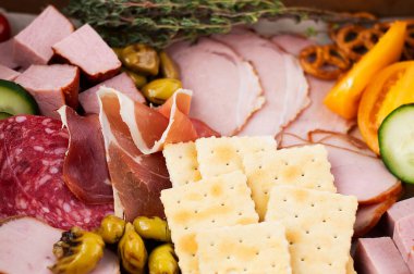 Jamon, salam, balyk, yeşillik, zeytin ve krakerin bulanık görüntüsü. Hızlı atıştırma konsepti.