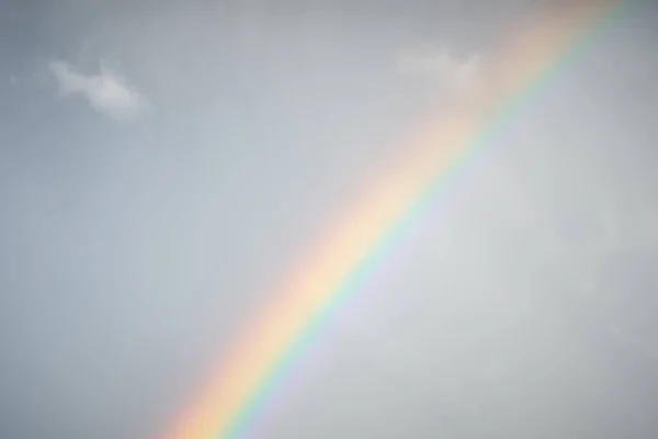 Multicolored rainbow on the background of a clear blue sky