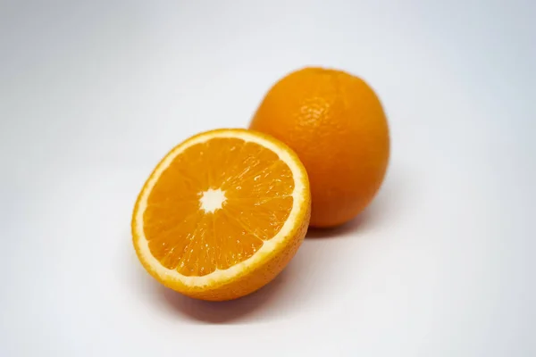 화이트 스튜디오의 화면에 전체와 반쪽짜리 오렌지 — 스톡 사진
