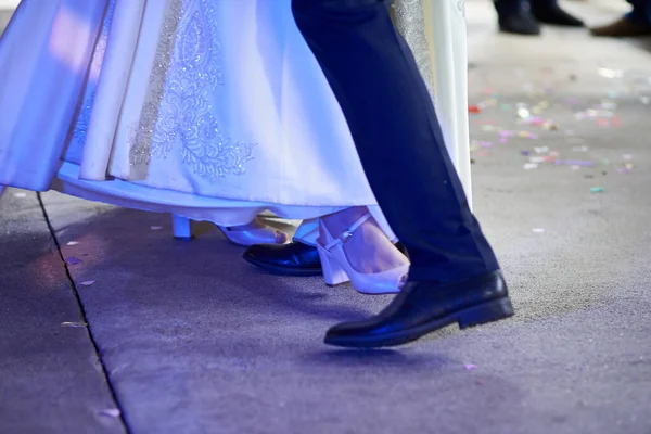Close-up of the legs of the newlyweds at the wedding, dancing their first wedding dance
