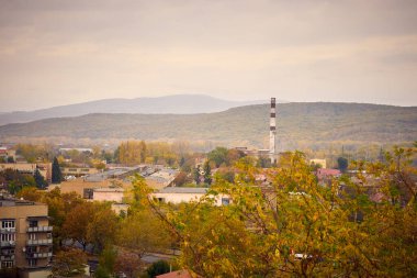 Sonbaharda şehir manzarası dağların arka planına karşı