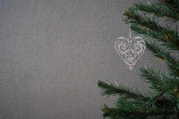 Kartpostal yapmak için kalp şeklinde oyuncakla süslenmiş bir Noel ağacının fotoğrafı.