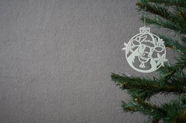 Noel ağacının resmi. Kartpostal yapmak için inek şeklinde ahşap bir yeni yıl oyuncağıyla süslenmiş.