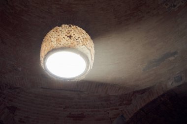 Taştan bir binada güneş ışığının düştüğü bir pencere.