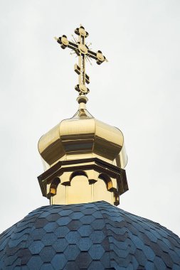 Mavi gökyüzüne karşı Hristiyan kilisesinin altın kubbesinin dikey yakın çekimi.
