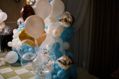 Üzerinde mavi, beyaz ve altın rengi balonlar olan bir dekorasyonun fotoğrafı