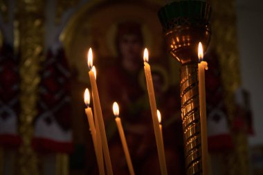 Kilisede yanan mumlarla dolu bir şamdan.